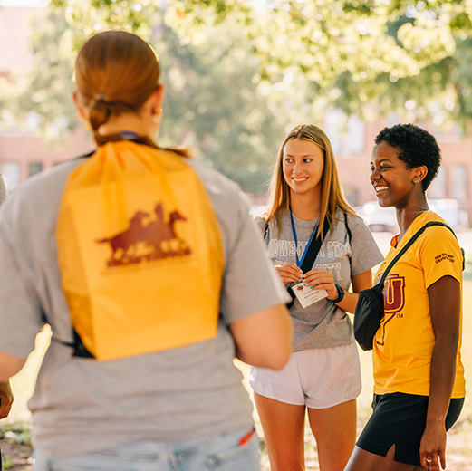 Group of students standing together, smiling, while standing in the quad at MSU Texas.